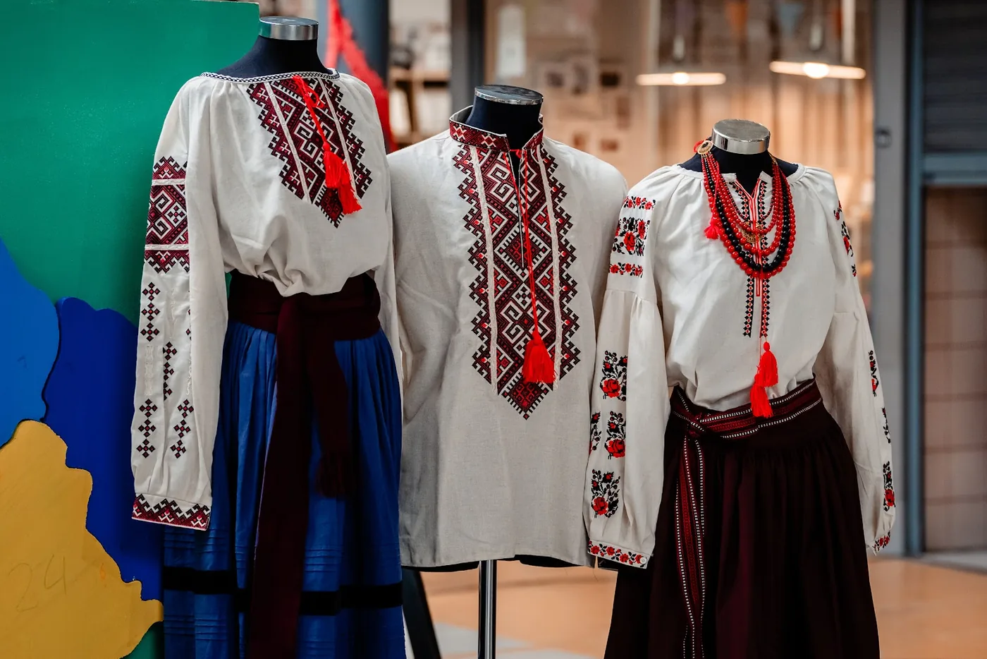 Trajes tradicionais ucranianos expostos em manequins no mercado.