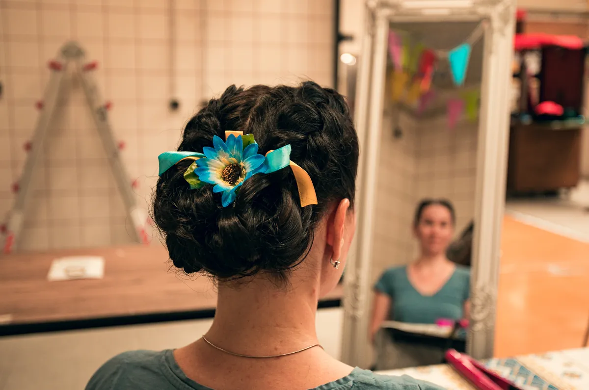 Penteado com uma flor amarela e fitas azuis, feito na zona de styling ucraniano.