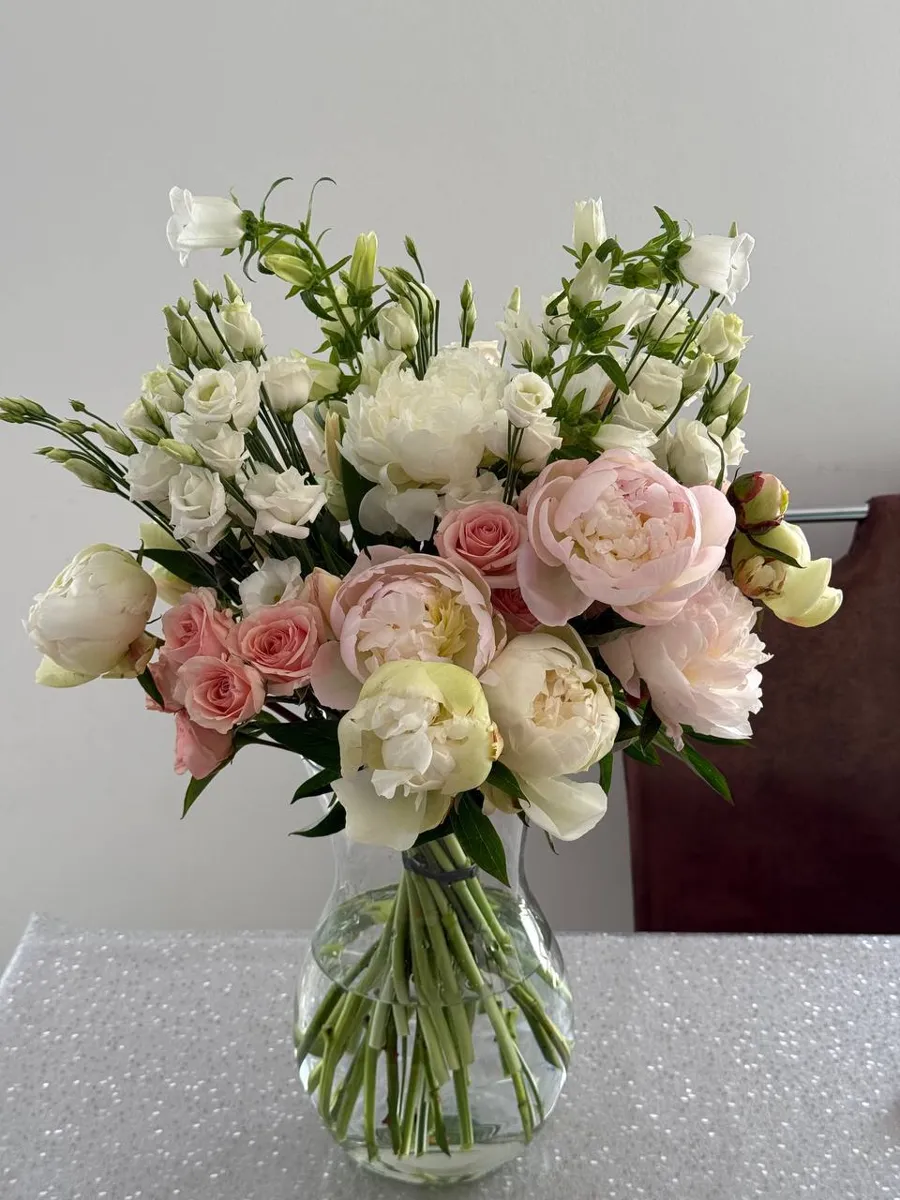Ramo de peónias em tons de rosa e branco.